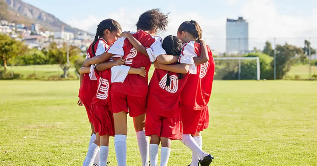Trans girls hugging at a soccer game.