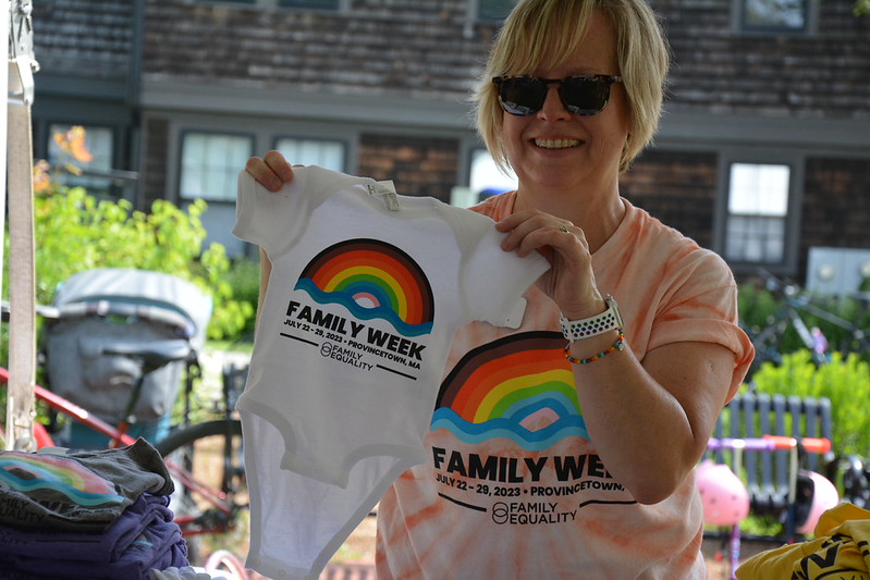 Woman holding up onesie with a rainbow