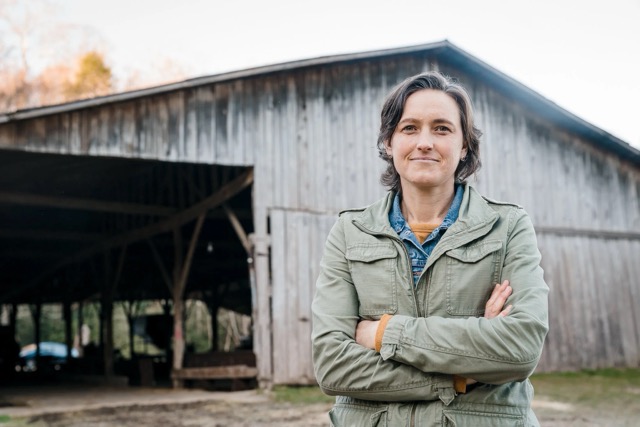 Woman standing in front of a barn